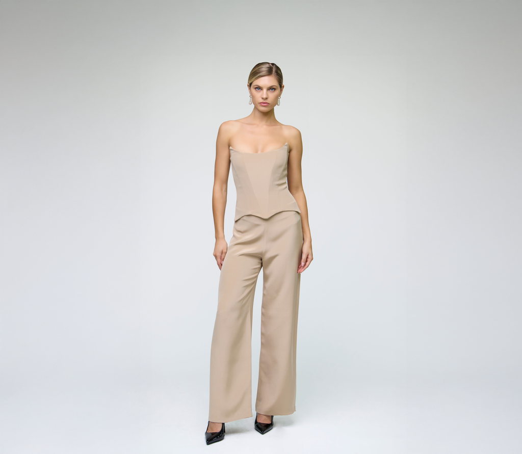 Model wearing a sand corset top styled with matching wide-leg trousers against a light grey background.
