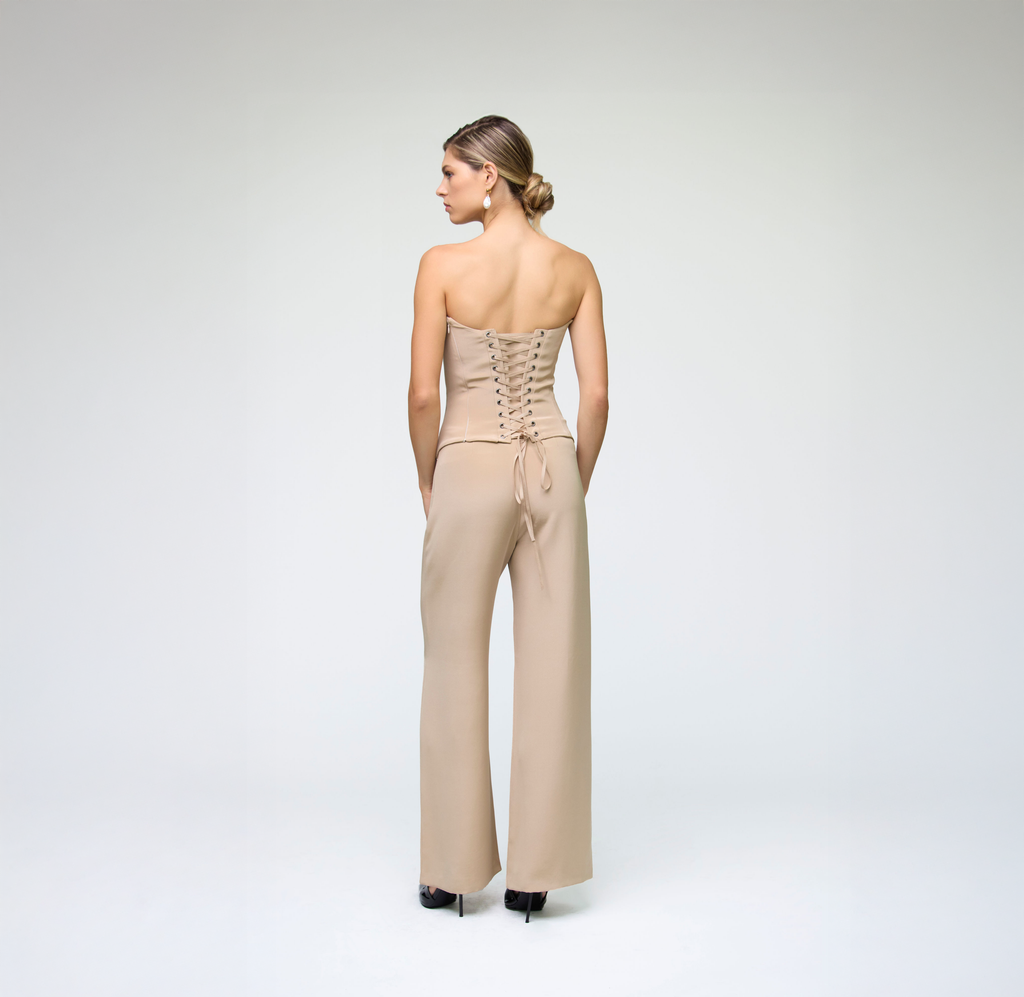 Back detail view of sand wide-leg trousers styled with a matching lace-up strapless top.