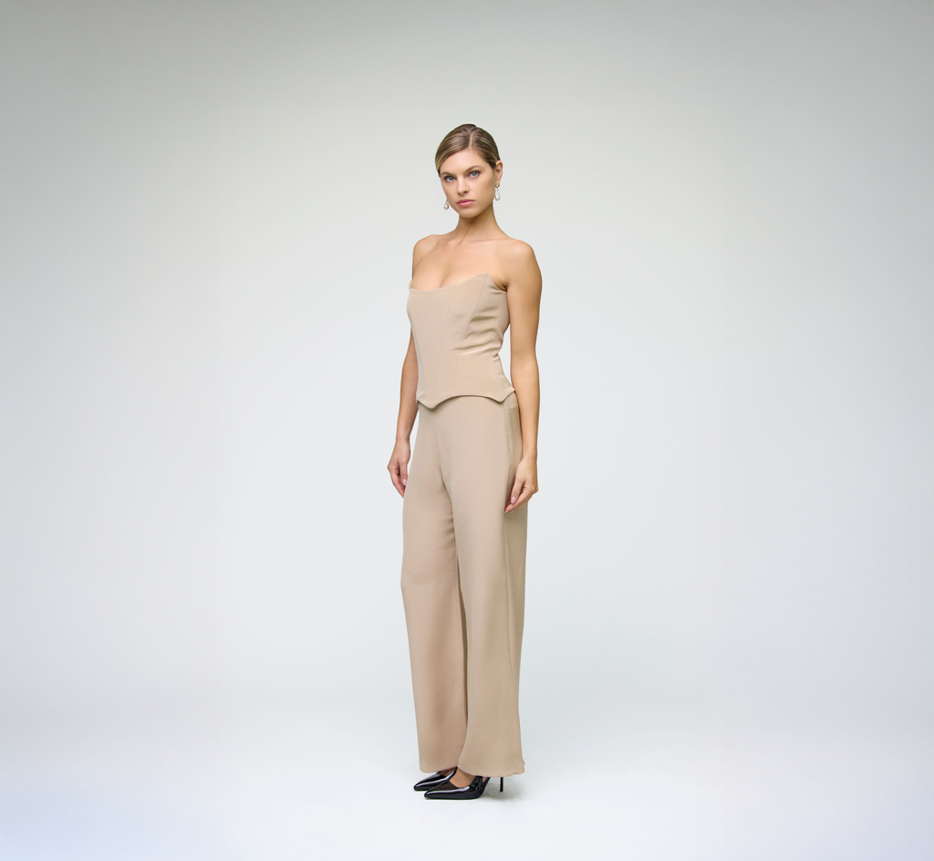 Model posing in sand wide-leg trousers styled with a matching strapless top at an angle against a light grey background.